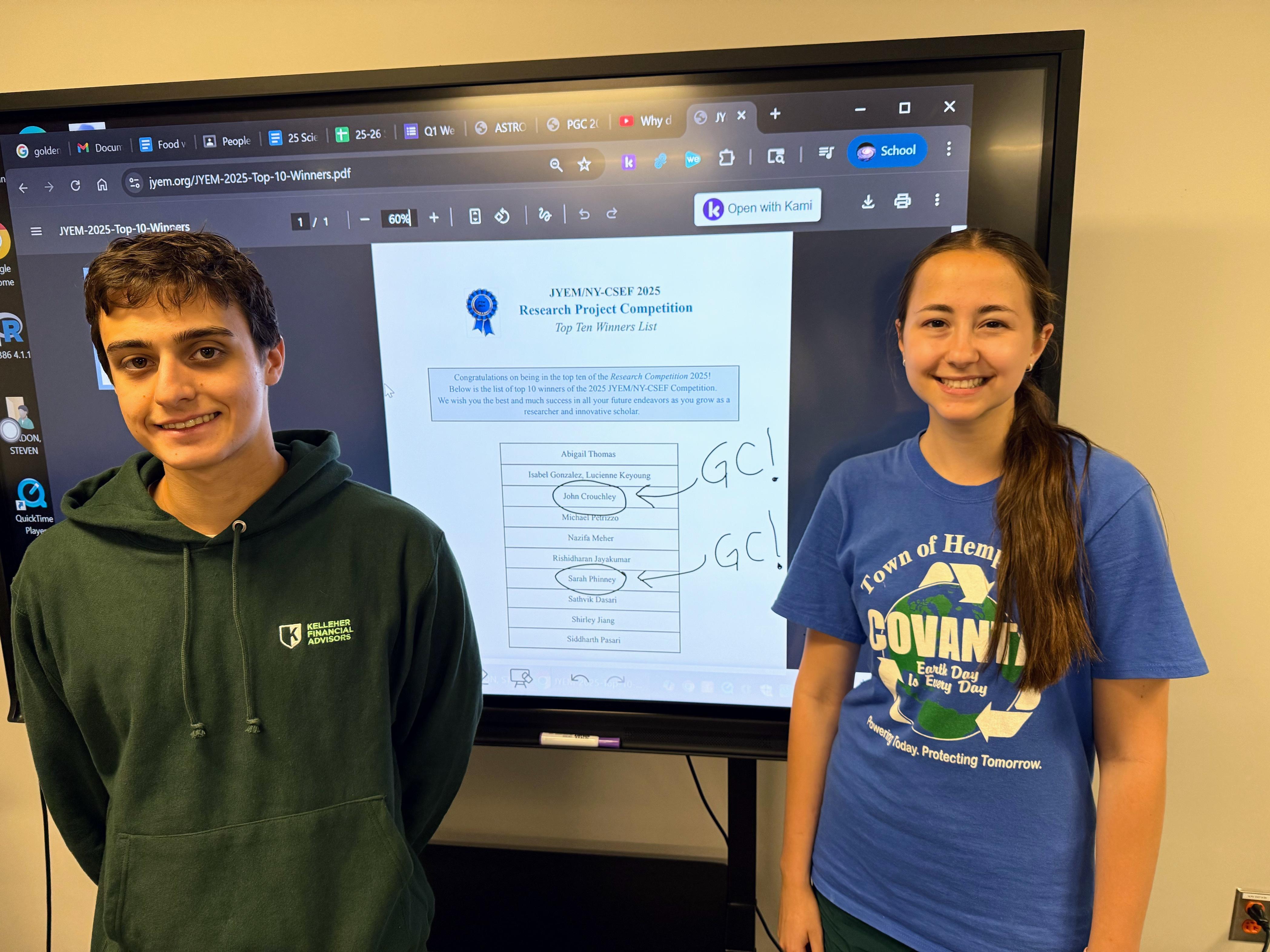 two student winners of junior scientist contest smiling at camera, one male one female
